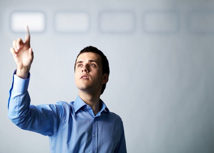 Image of young businessman pointing at virtual button